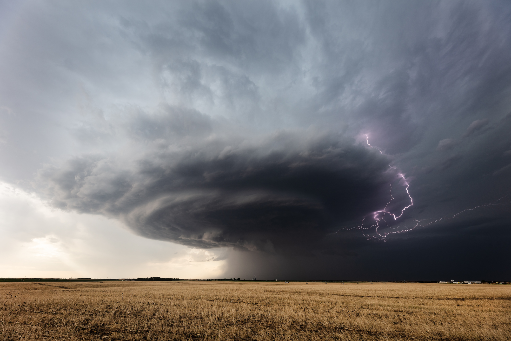 Lightning strikes from a powerful supercell thunderstorm over a field near Greensburg, Kansas.