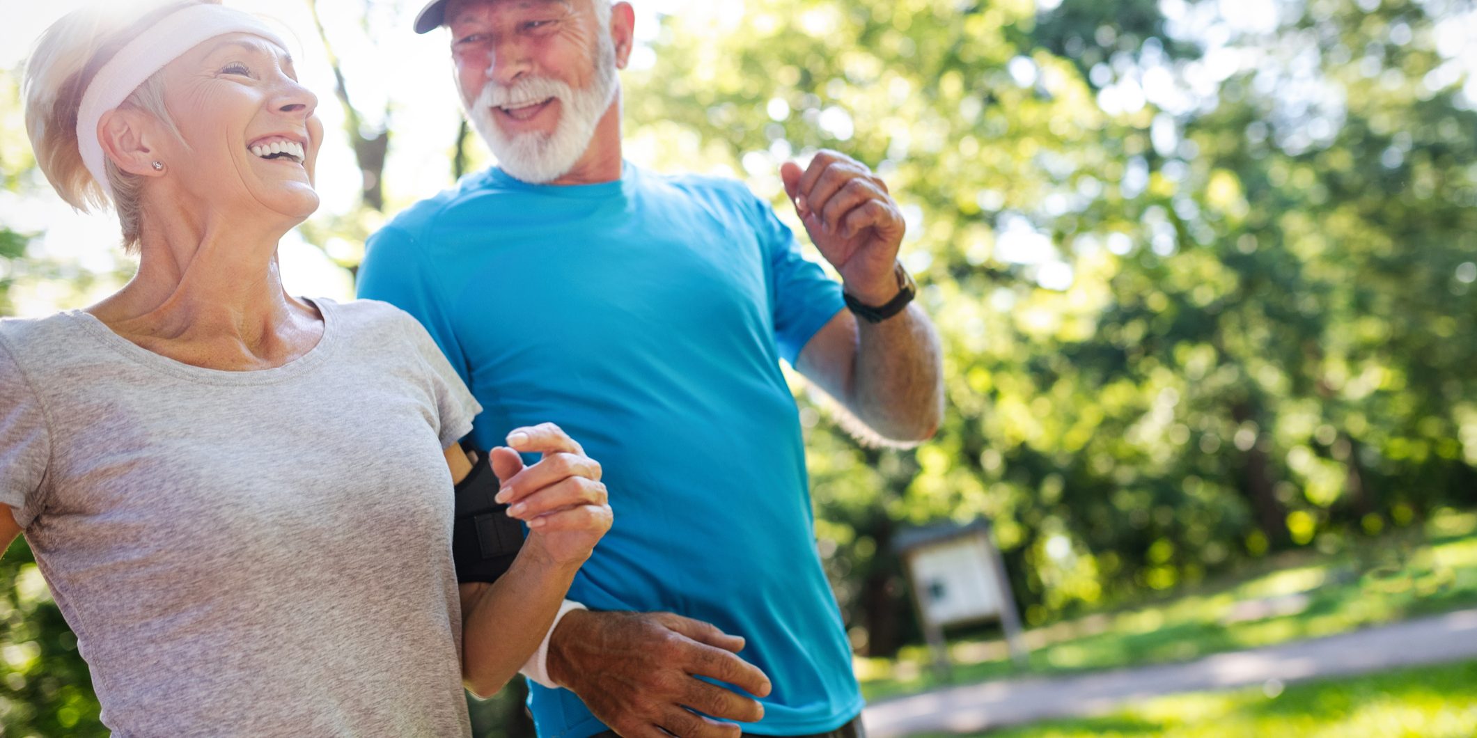 Beautiful senior couple jogging in nature living healthy