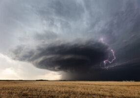 Lightning strikes from a powerful supercell thunderstorm over a field near Greensburg, Kansas.