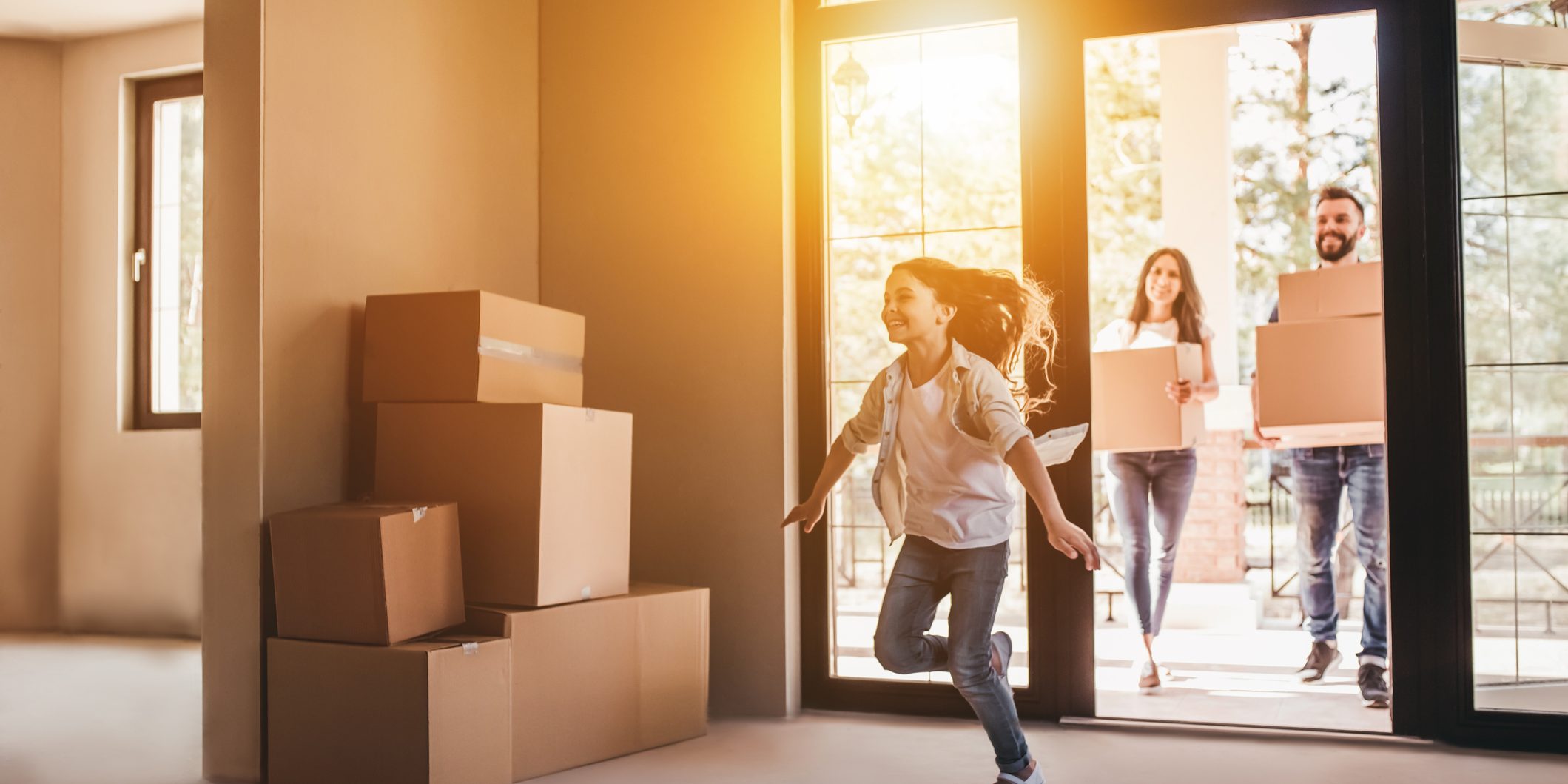 Happy family with cardboard boxes in new house at moving day.